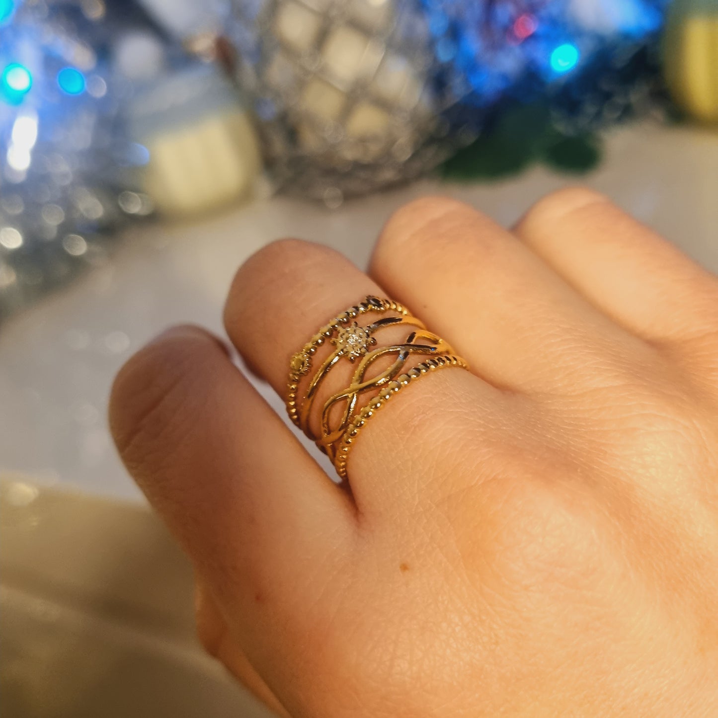 Bague en acier inoxydable dorée et ajustable, photo portée. Multirang, avec motif soleil, et maille entremêlée. Idéal comme cadeau pour femmes.