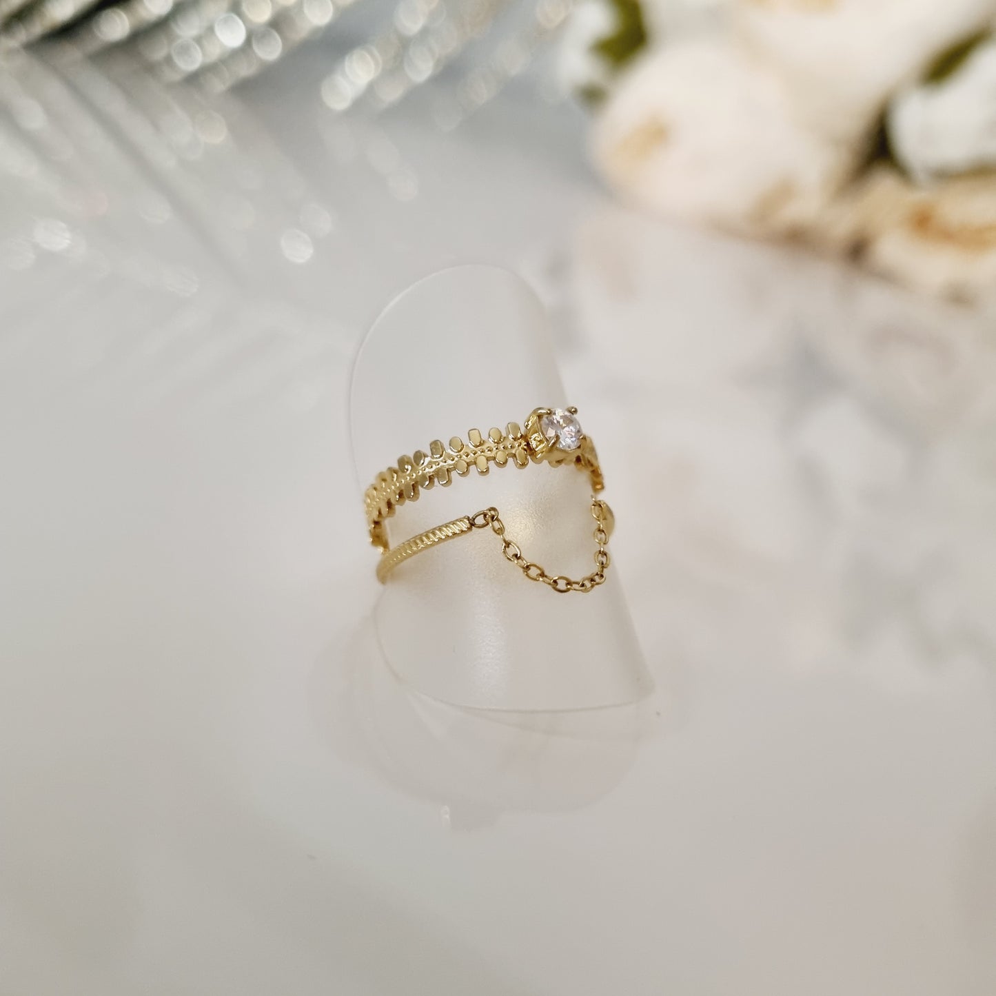 Bague dorée en acier inoxydable pour femme. Taille réglable. Avec pierre centrale en zircon. Multirang double, avec chaine pendante