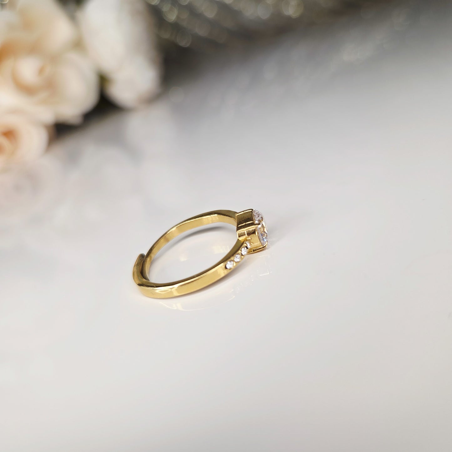 Bague dorée femme en acier inoxydable avec zircon rond central et incrustations de pierres scintillantes, bijou élégant et raffiné idéal pour mariage, fiançailles ou cadeau. Vue de derrière, sur la partie réglable.