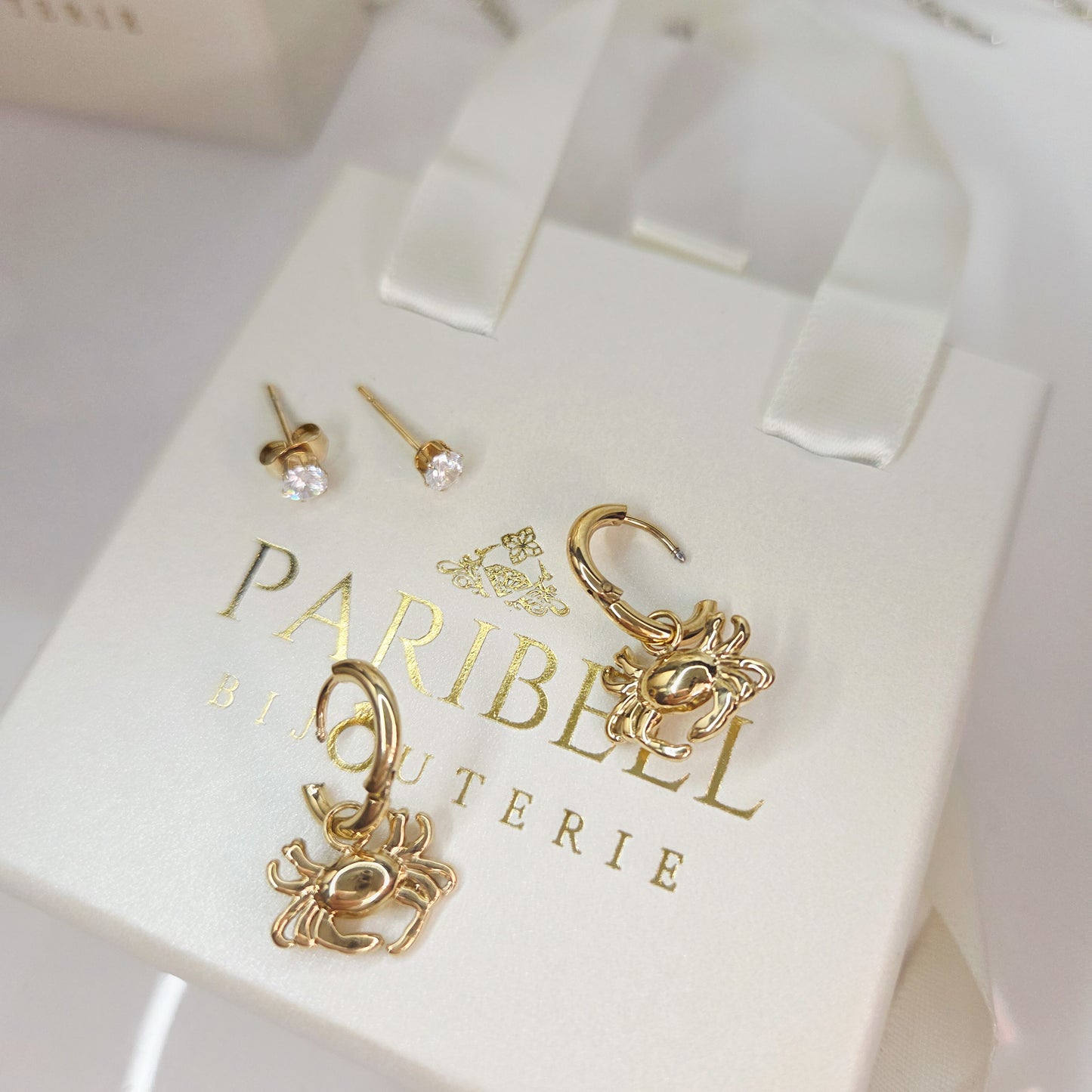 Paire de boucles d’oreilles anneaux avec pendentif crabe et clous inclus. Bijou original au style marin, élégant et facile à porter.