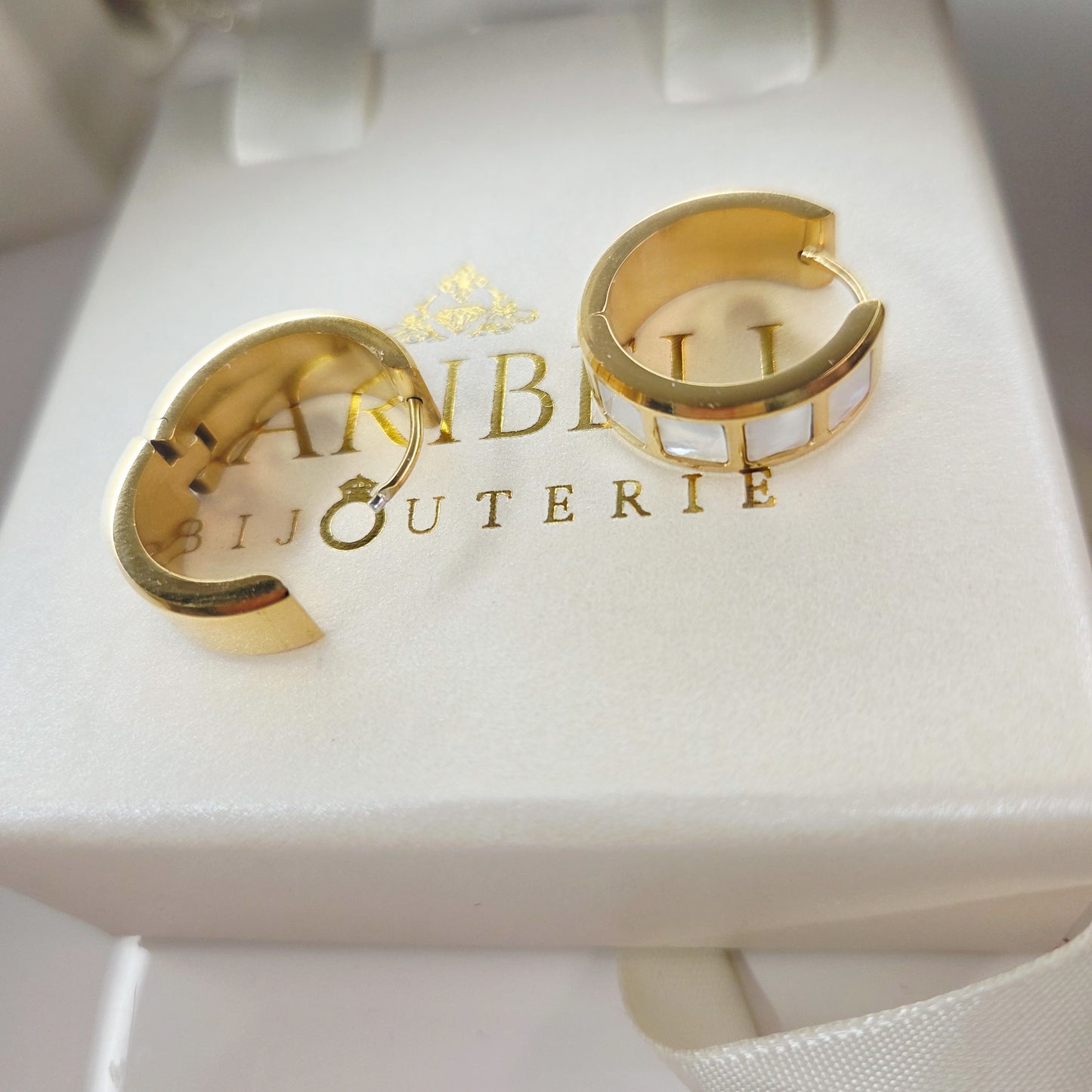 Paire de boucles d’oreilles anneaux larges avec incrustations nacrées. Bijou élégant et moderne, idéal pour un style chic au quotidien.