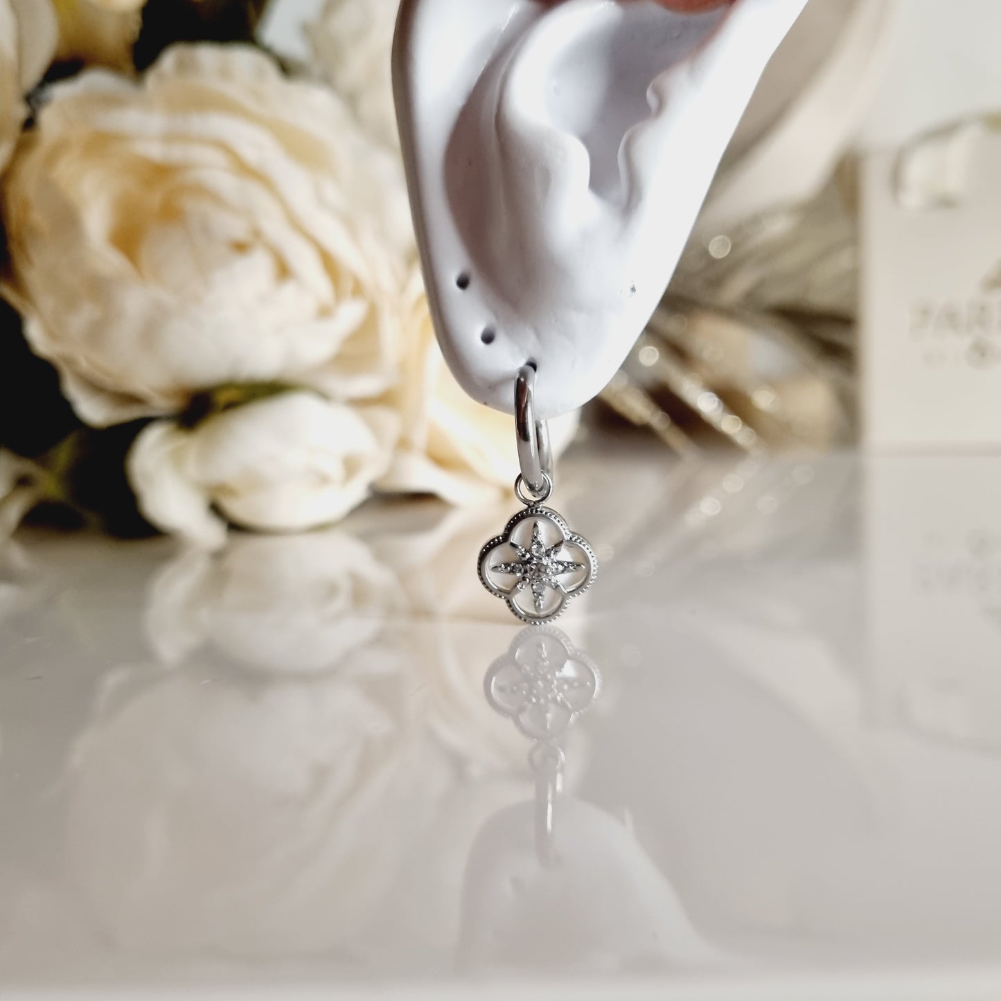 Boucles d’oreilles Éliséa en acier inoxydable argenté, créoles avec breloque trèfle blanc nacré et étoile ornée de zirconium.