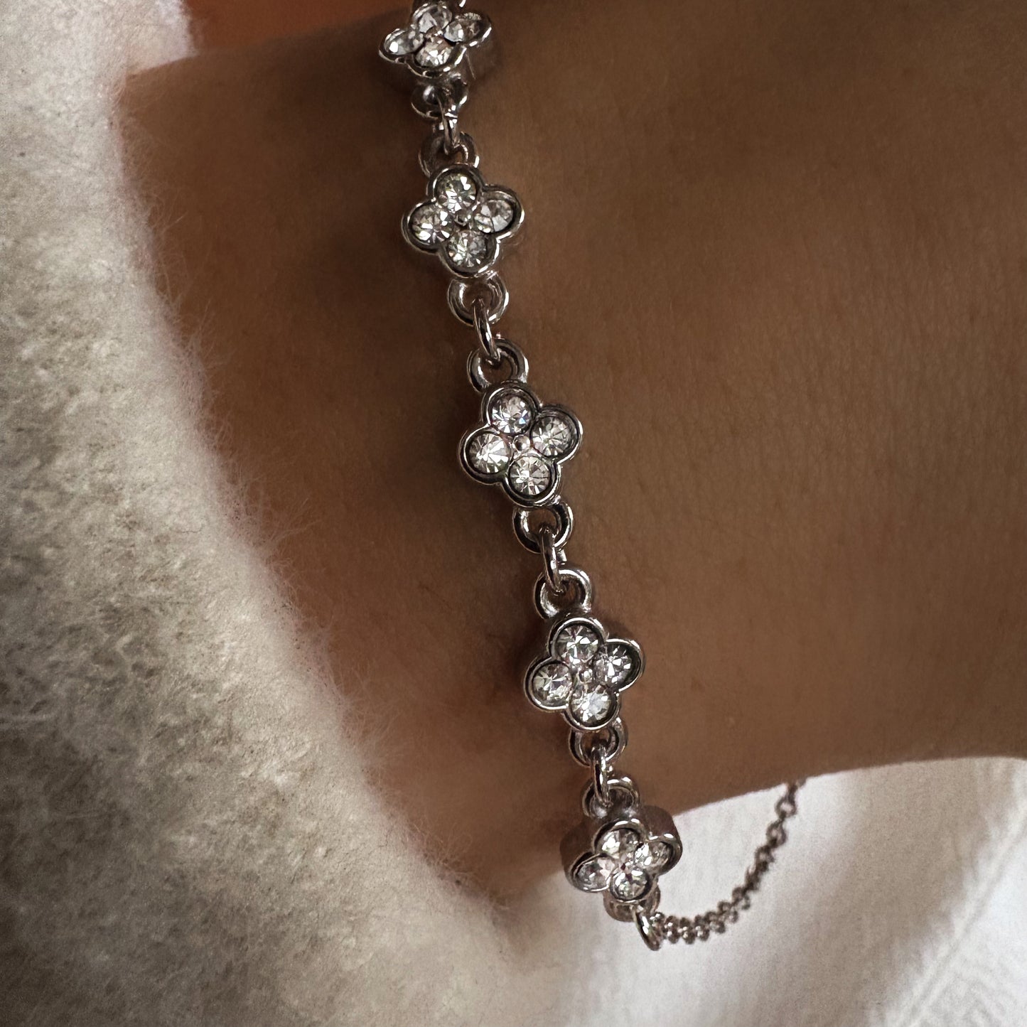 Bracelet élégant à motifs fleurs avec zircons scintillants, bijou féminin porté au poignet. Zoom sur le bracetet.