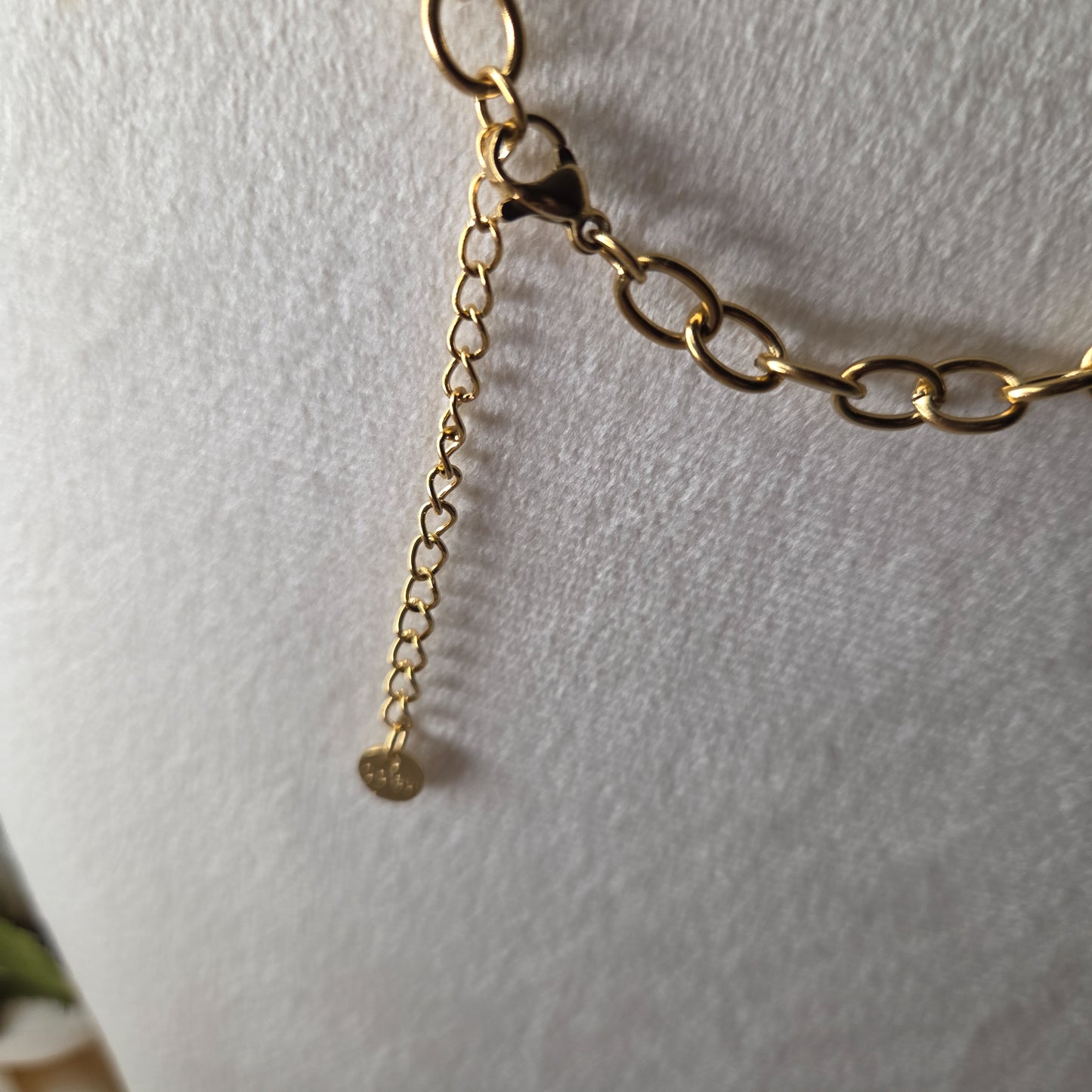 Collier doré en acier inoxydable avec pendentifs marins : étoile de mer, coquillages, corail et perle. Original, chic et résistant.