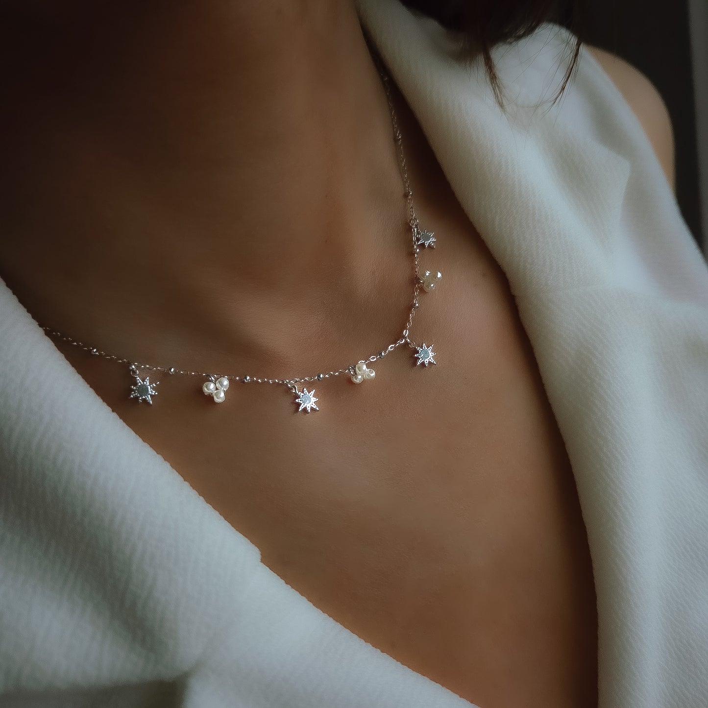 Collier fin à pampilles étoiles et perles porté autour du cou, bijou délicat et élégant