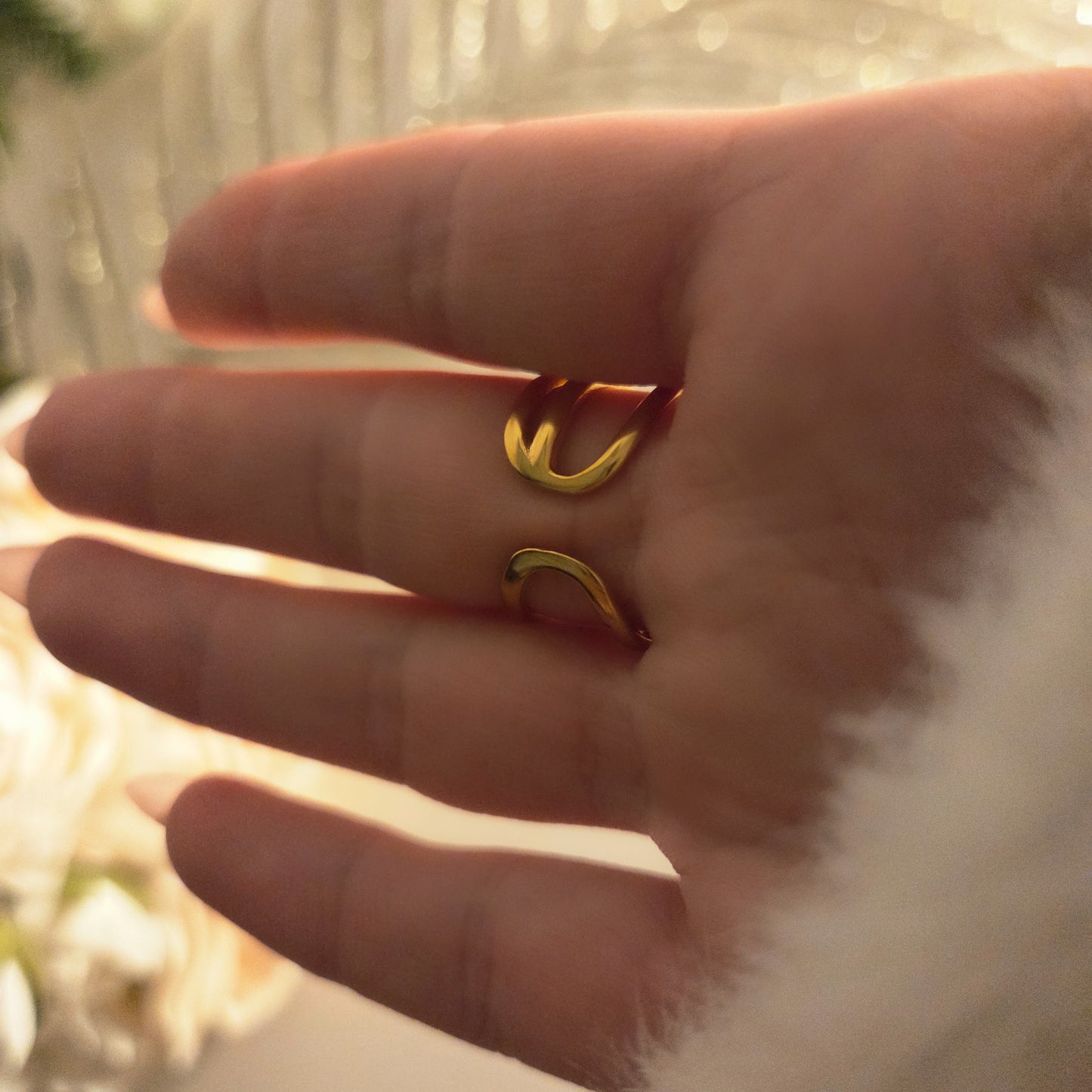 Bague dorée multi-rangs avec strass brillants portée au doigt