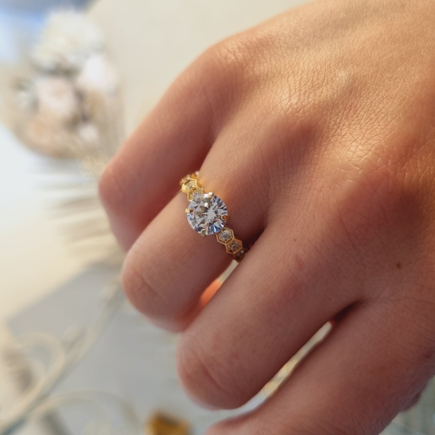 Bague dorée en acier inoxydable, vue portée, avec pierre zirconium ronde et pierres latérales