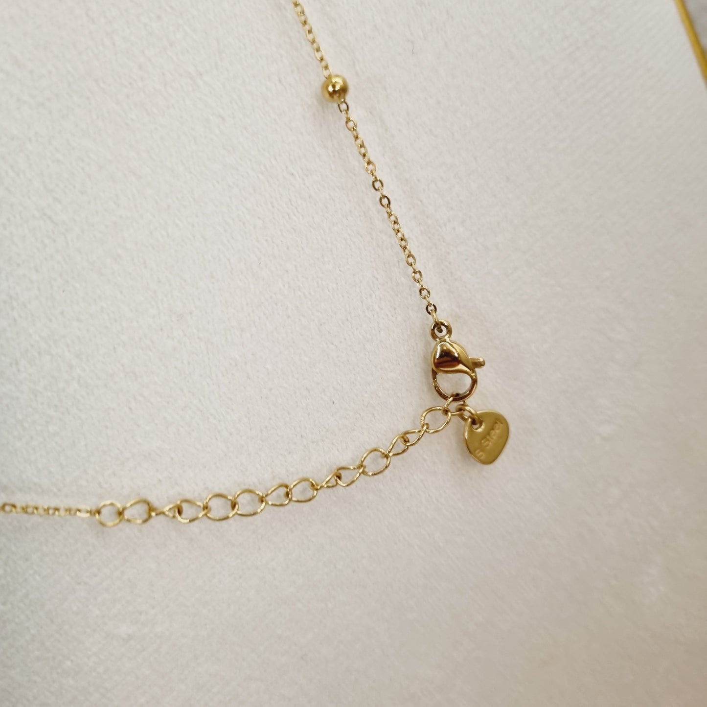 Élégant collier sautoir en acier inoxydable doré avec perles délicates. Un accessoire féminin pour sublimer chaque tenue.