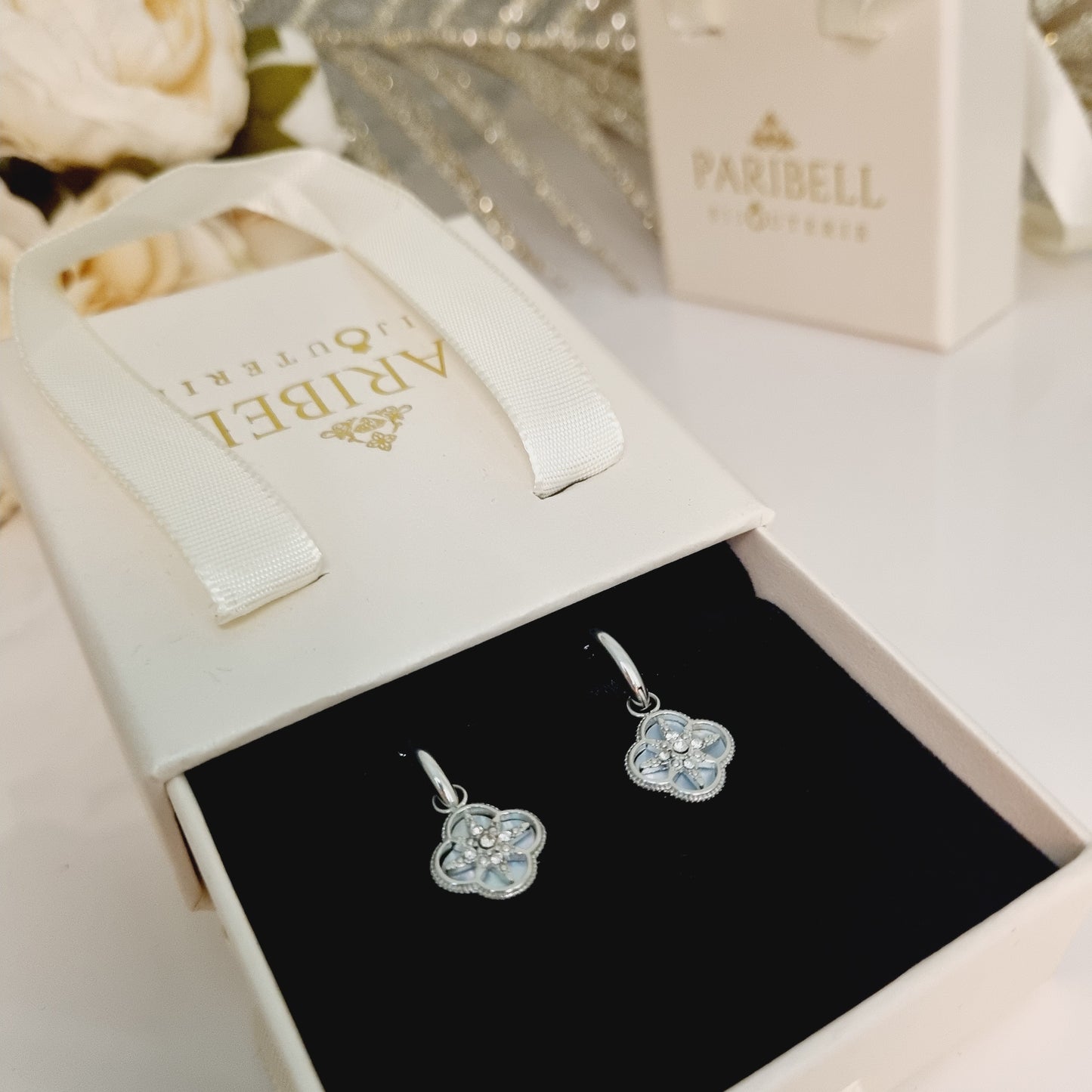 Créoles argentées en acier inoxydable avec pendentif trèfle à quatre feuilles en pierre nacrée et étoile en zircon.