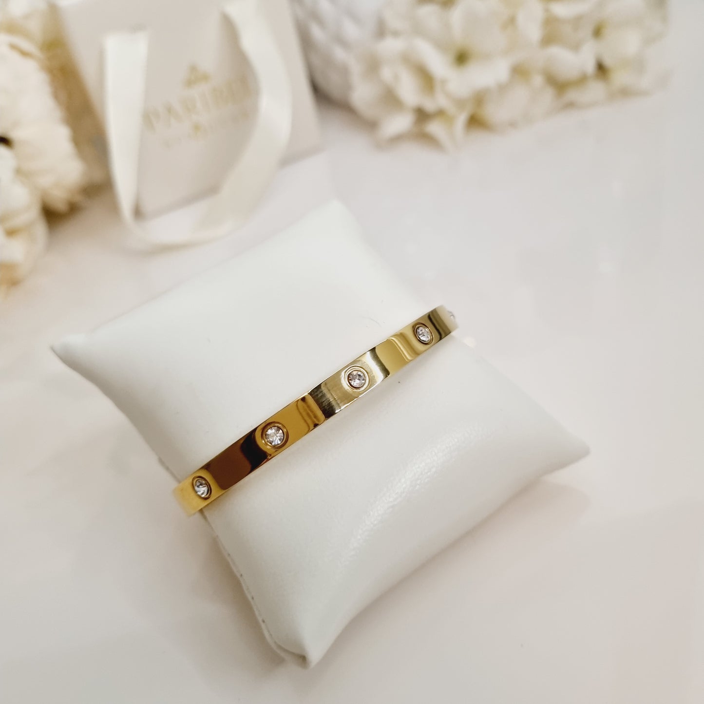 Bracelet jonc doré en acier inoxydable avec petites pierres strass, élégant et résistant.
