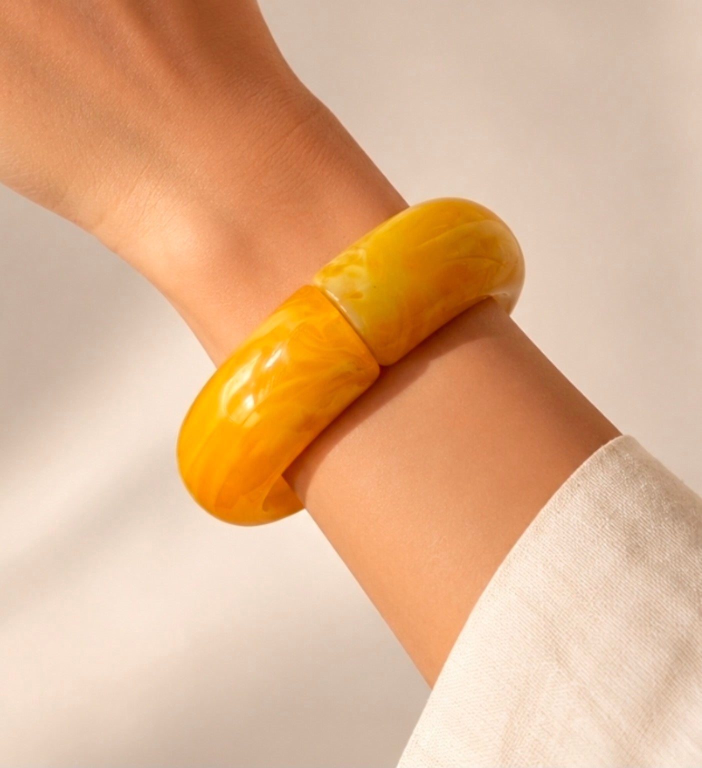 Bracelet jonc large jaune effet marbré porté au poignet