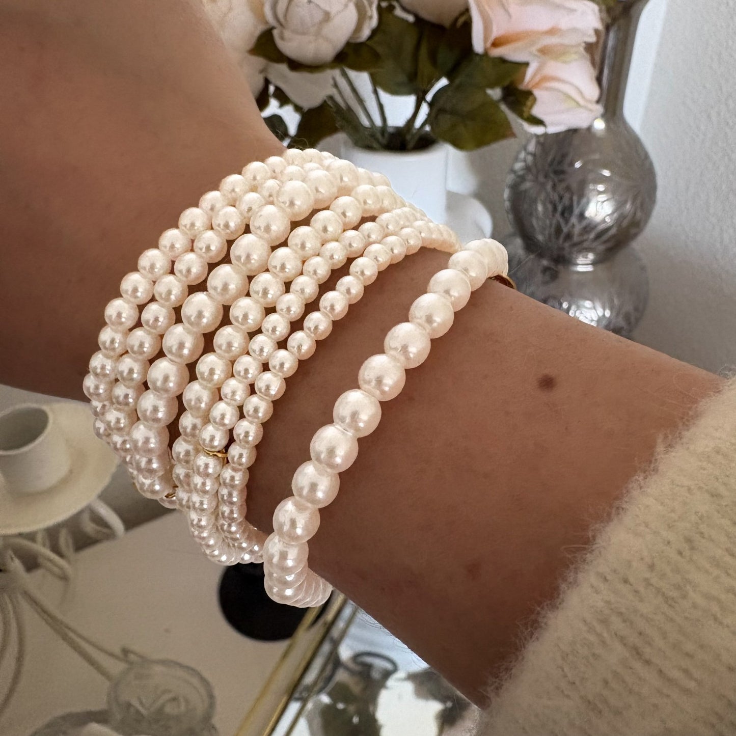 Bracelet multirangs en perles blanches porté au poignet