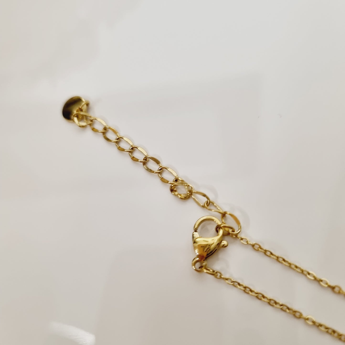 Sublimez votre style avec le collier Lyria, un bijou doré raffiné avec un pendentif trèfle à 4 feuilles orné de strass. Élégant et porte-bonheur.