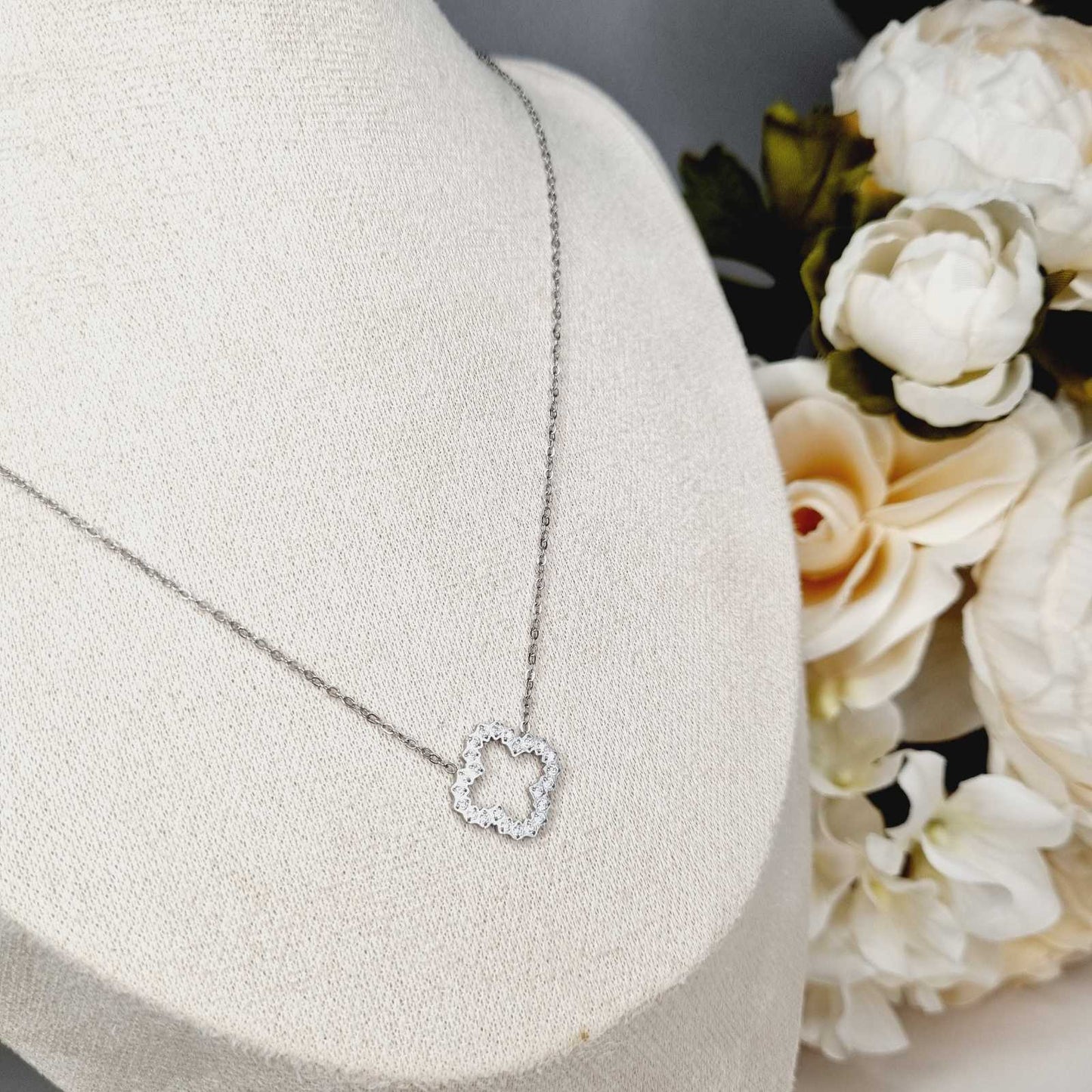 Collier en acier inoxydable couleur argent, en forme de trèfle à 4 feuilles avec strass zircons. La longueur peut s'ajuster. L'acier chirurgical / inox / inoxydable (peut être appelé de plusieurs manières différentes) résiste à l'eau et à tout type de liquide. Vous pouvez dormir avec, vous laver/baigner avec, faire du ménage avec sans craindre que la bague ne s'abime. Cette matière garde son éclat au fil des années et est hypoallergénique, elle convient donc pour les personnes sujettes aux allergies.