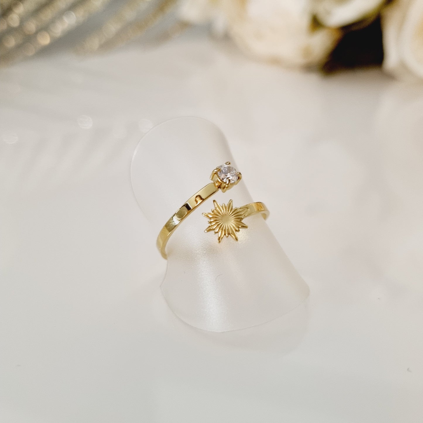 Bague en acier inoxydable couleur or avec motif soleil et zircon. Taille réglable, convient à toutes les tailles. L'acier chirurgical / inox / inoxydable (peut être appelé de plusieurs manières différentes) résiste à l'eau et à tout type de liquide. Vous pouvez dormir avec, vous laver/baigner avec, faire du ménage avec sans craindre que la bague ne s'abime. Cette matière garde son éclat au fil des années et est hypoallergénique, elle convient donc pour les personnes sujettes aux allergies.