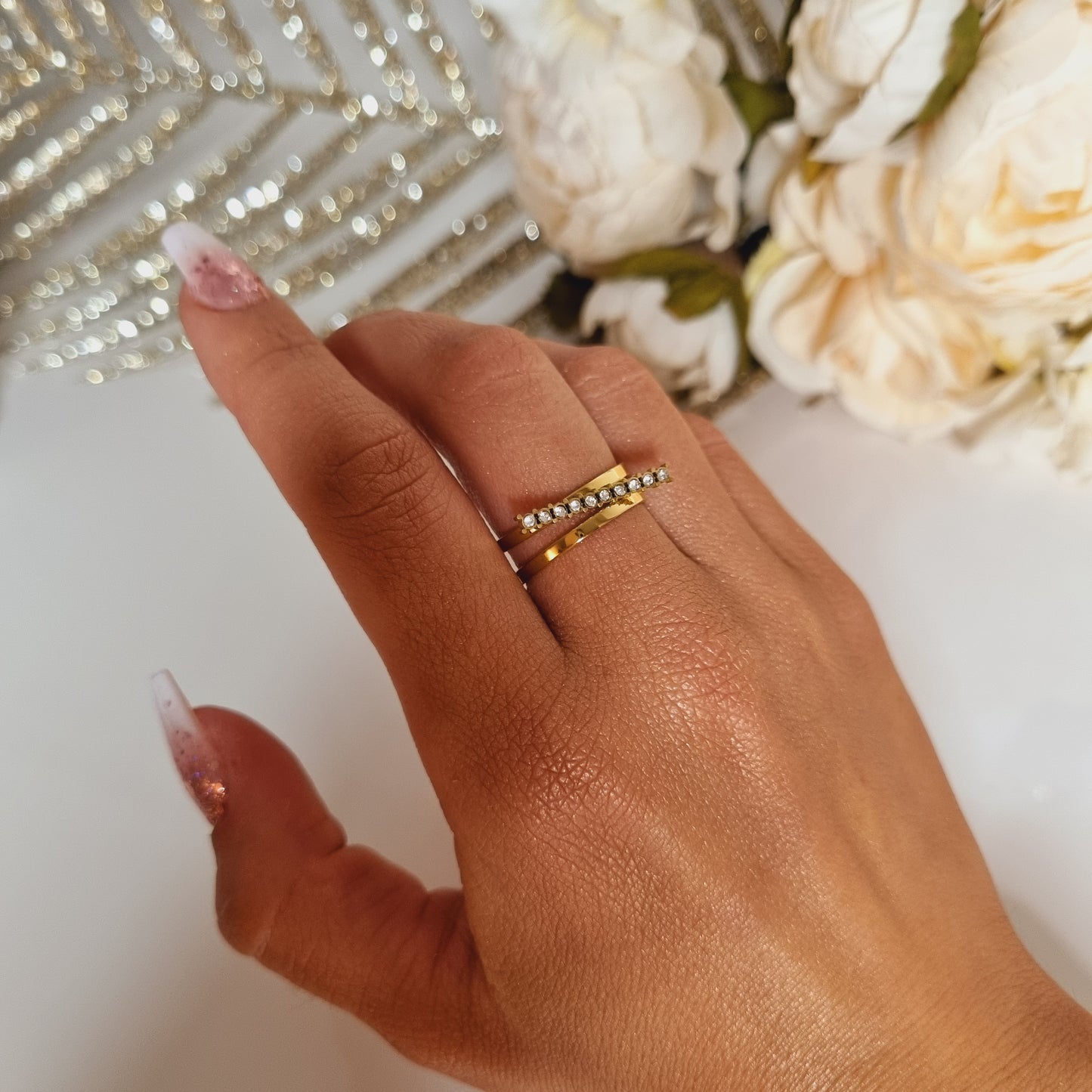 Bague en acier inoxydable couleur or avec barre à strass Taille réglable, convient pour toutes les tailles de doigts, peut se serrer et se desserrer. L'acier chirurgical / inox / inoxydable (peut être appelé de plusieurs manières différentes) résiste à l'eau et à tout type de liquide. Cette matière garde son éclat au fil des années et est hypoallergénique, elle convient donc pour les personnes sujettes aux allergies.