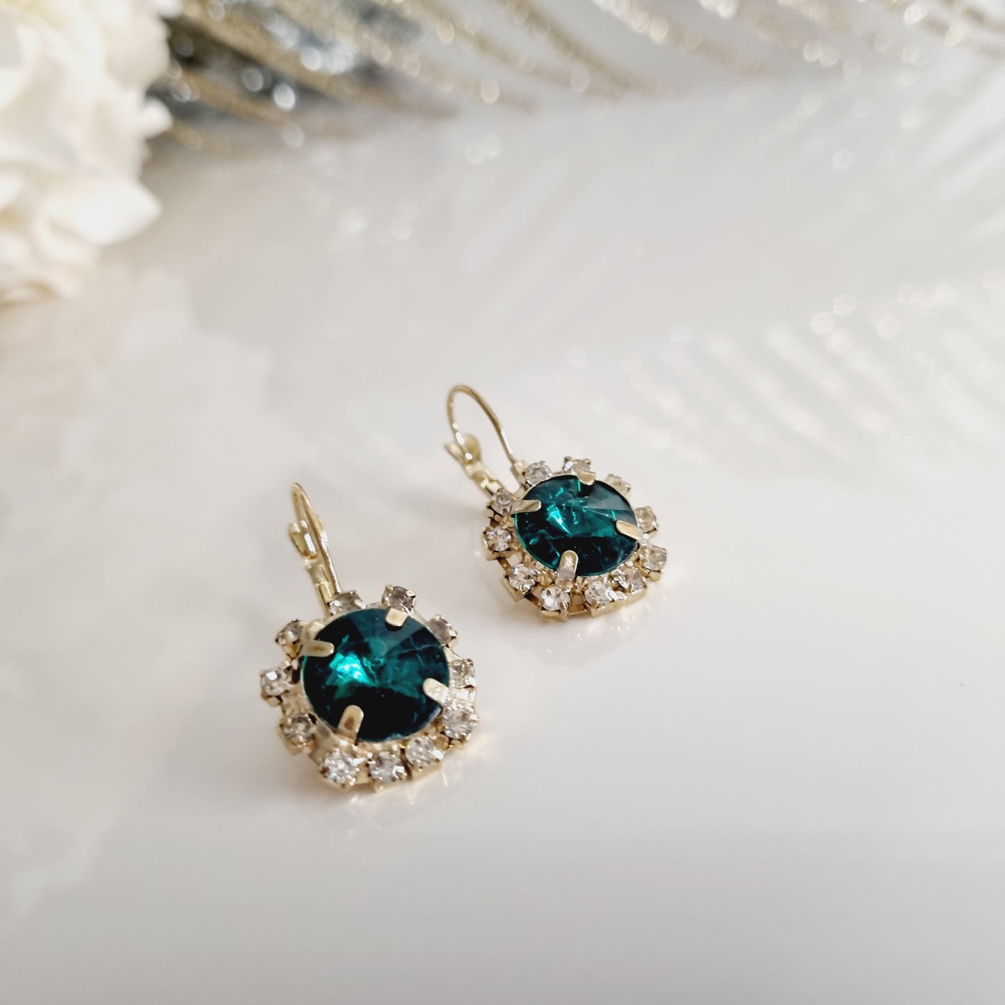 Découvrez nos élégantes boucles d'oreilles vertes et dorées, ornées d'une pierre verte éclatante entourée de strass scintillants. Parfaites pour ajouter une touche de sophistication et de glamour à n'importe quelle tenue. Caractéristiques : - **Design** : Pierre verte entourée de strass - **Couleur** : Vert et doré - **Matériau** : Laiton Ces boucles d'oreilles sont idéales pour les occasions spéciales ou pour apporter une touche d'élégance à votre style quotidien