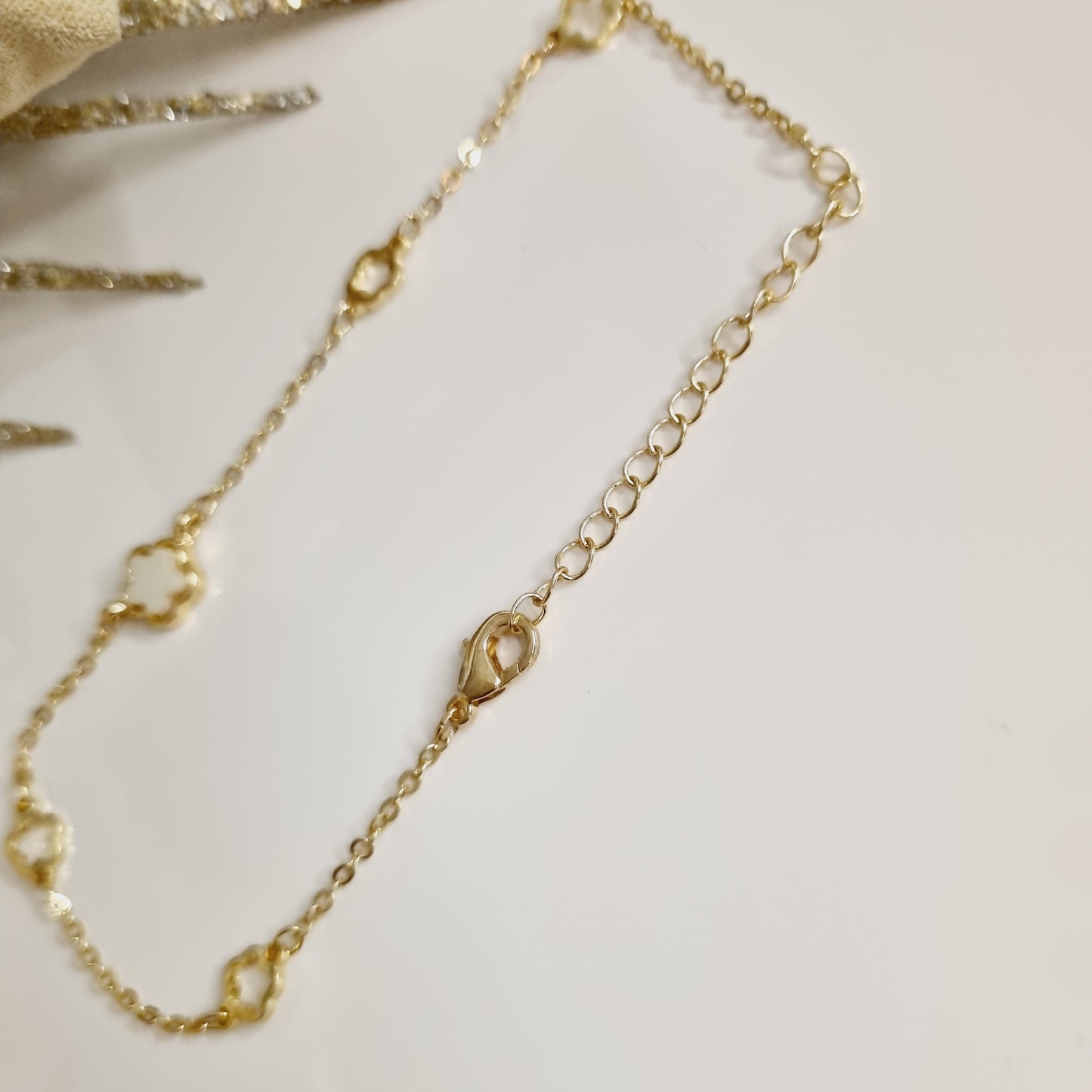 Bracelet doré avec trèfles à 5 feuilles et pierre blanche Laiton