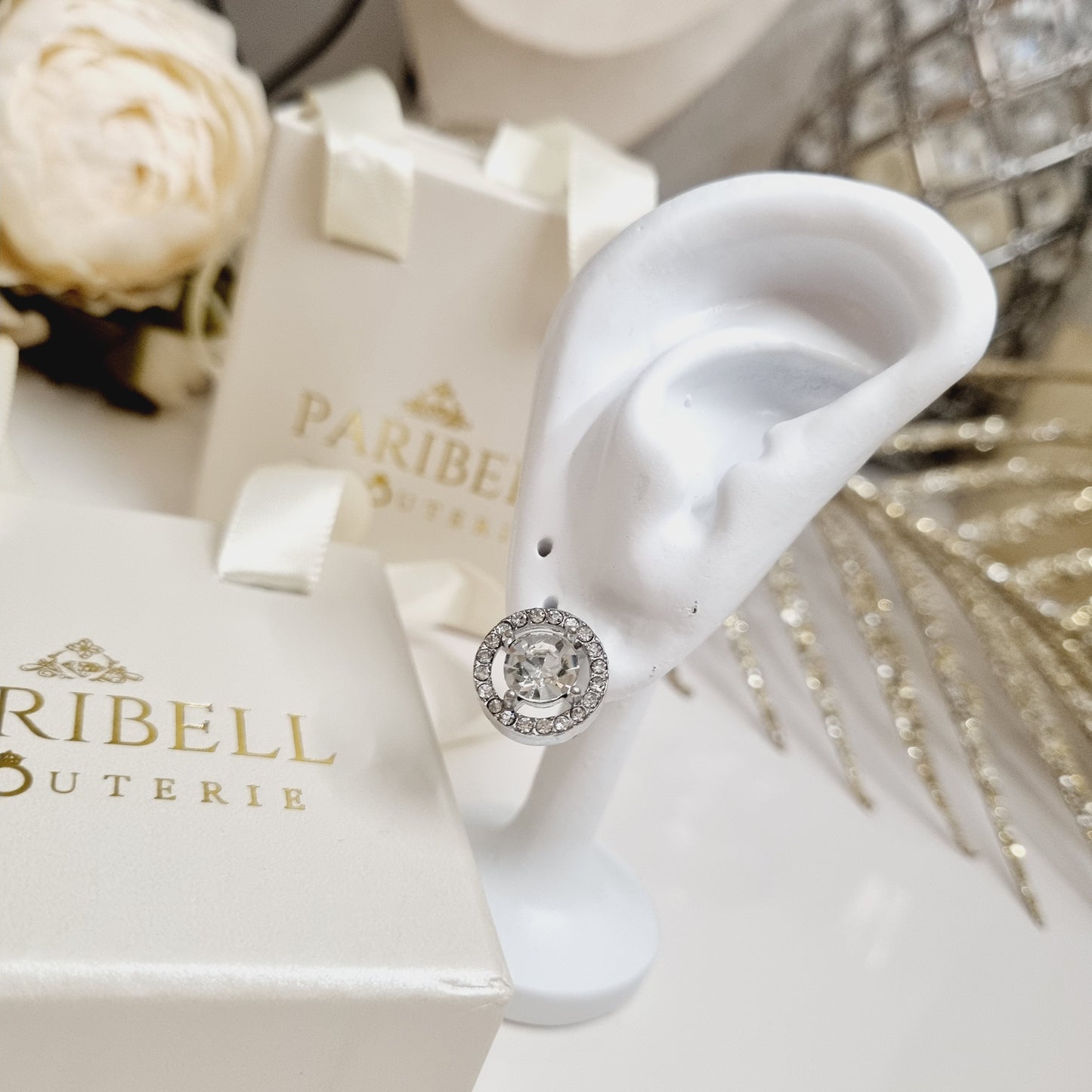 Photo portée des boucles d'oreilles rondes argentées ornées de strass