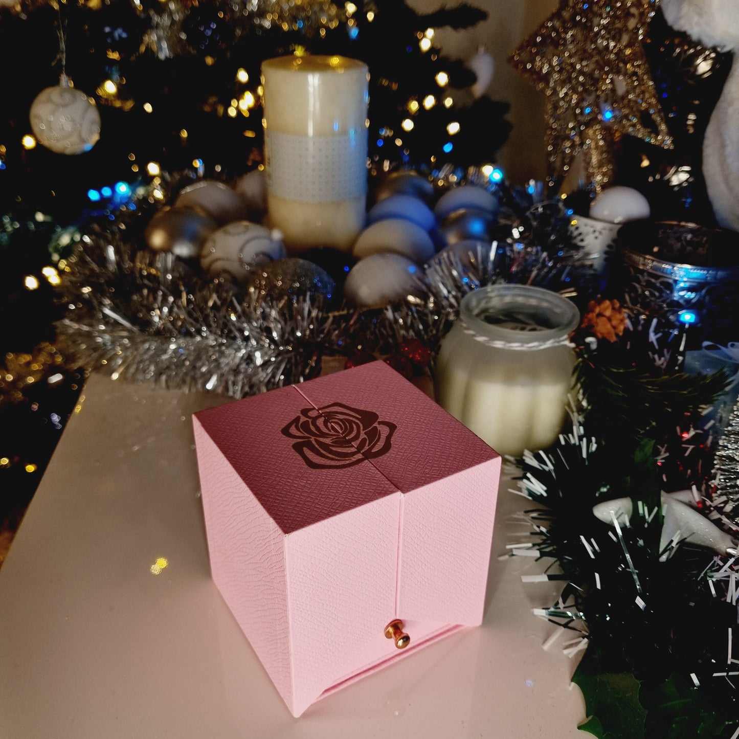 Boîte cadeau, vue fermée, couleur rose; avec jolie rose dorée comme motif. Pour offrir à une femme. Cadeau réussi, qui suscitera beaucoup d'émotions garanti.