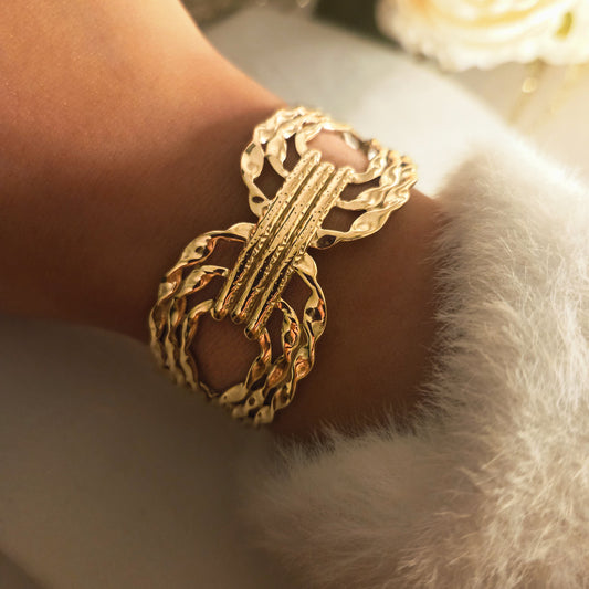 Bracelet manchette doré ajouré et martelé en acier inoxydable porté au poignet