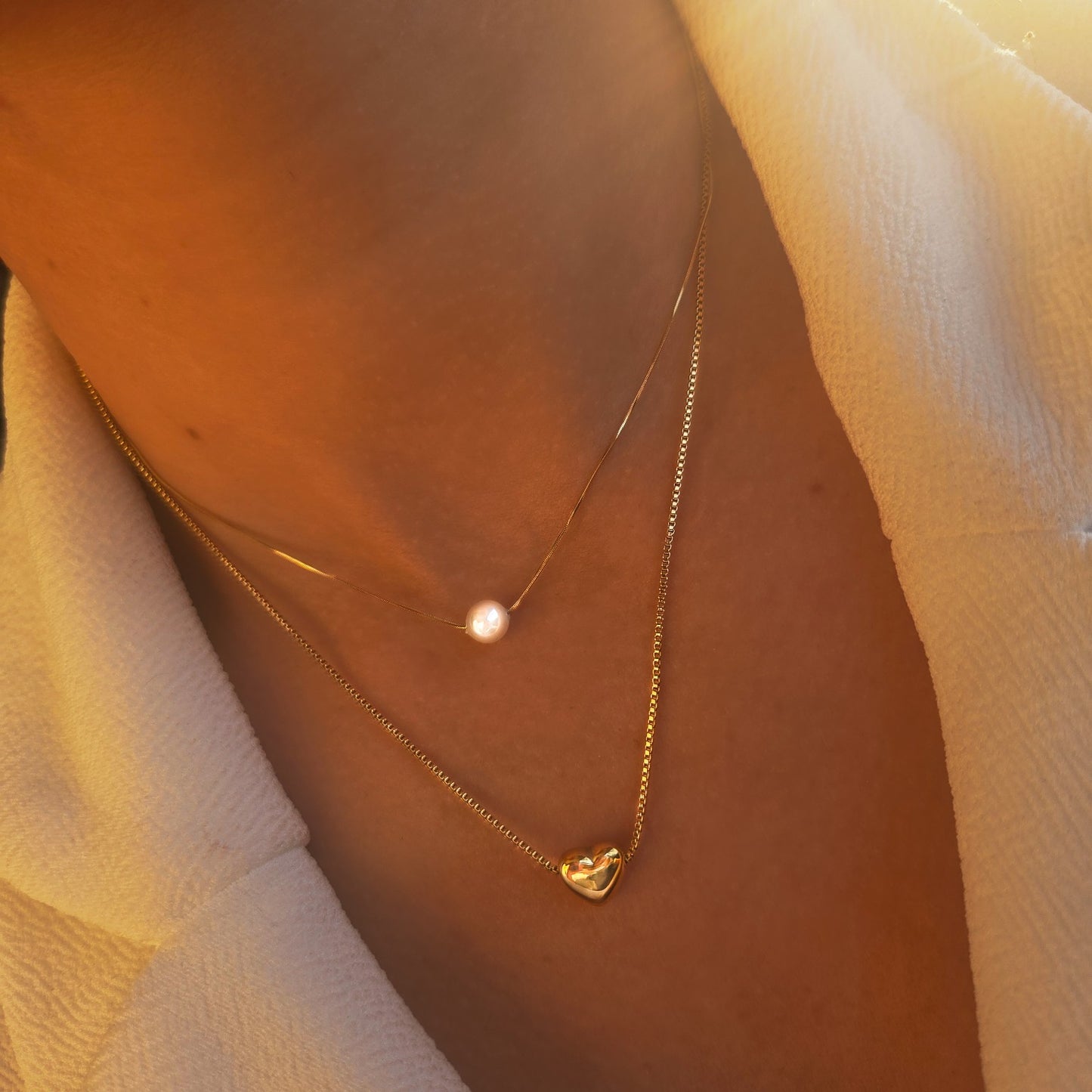 Collier double rang doré cœur et perle blanche porté