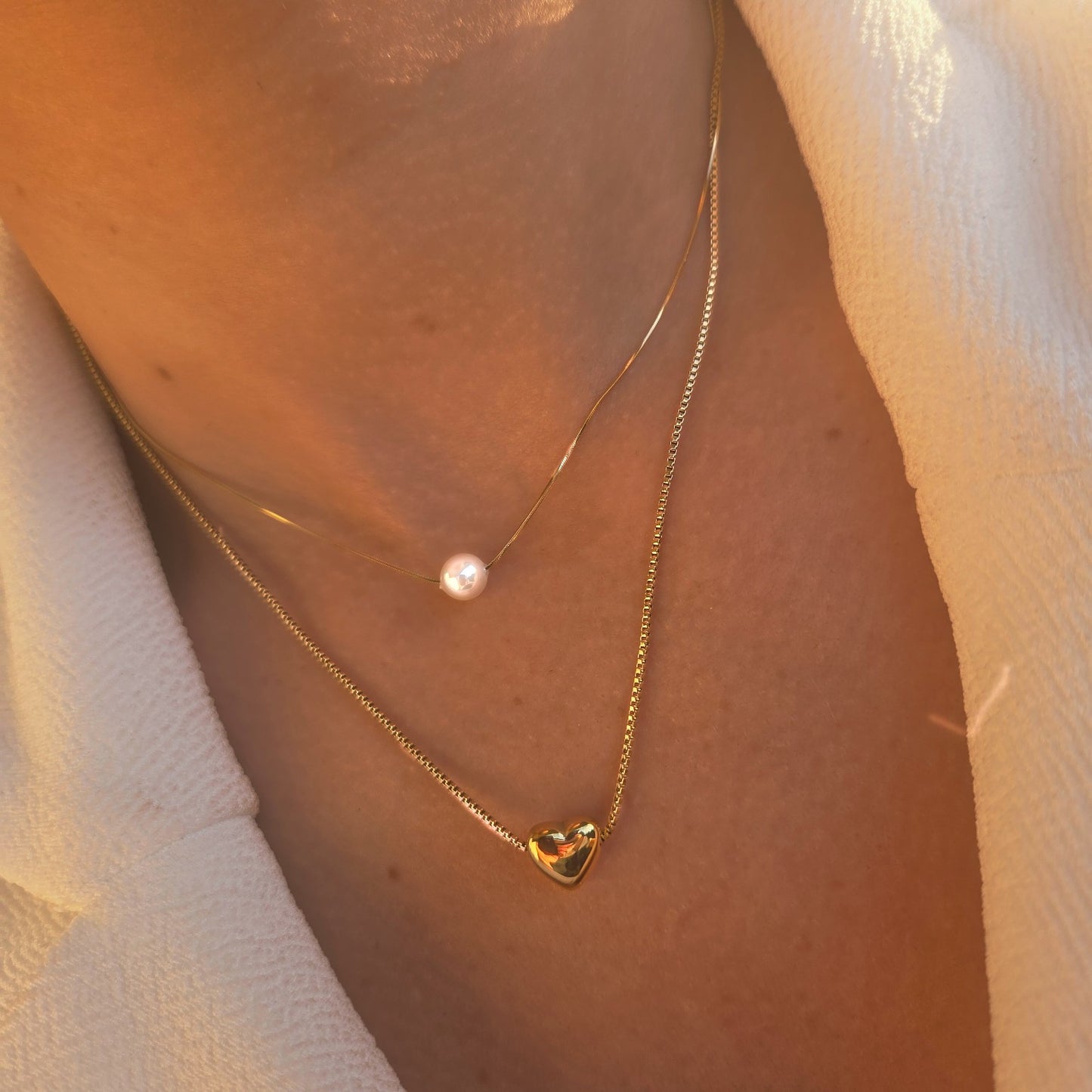 Collier double rang doré avec cœur et perle blanche