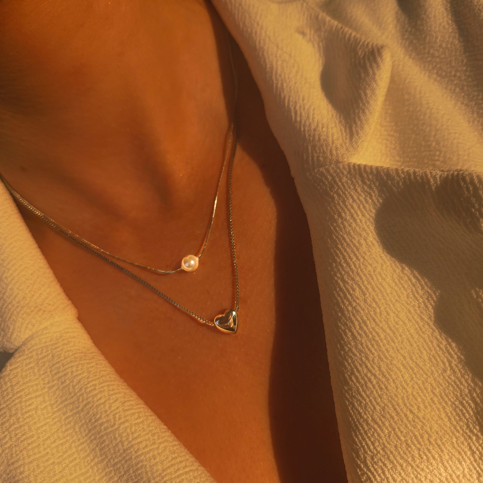 Collier double rang argenté cœur et perle blanche porté