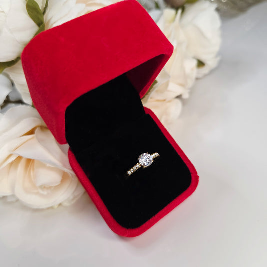 Bague ajustable pour femme en acier inoxydable, ornée d’une pierre centrale brillante. Bijou raffiné, hypoallergénique et résistant à l’eau, présenté dans un écrin rouge élégant.
