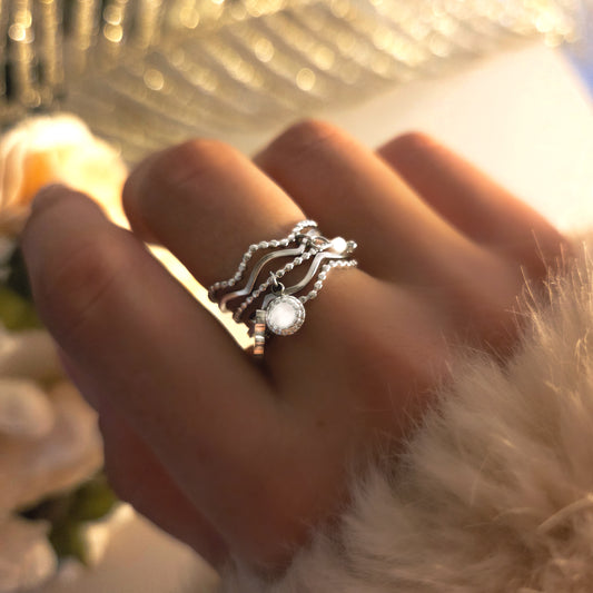 Bague argentée ajustable en acier inoxydable, multi-anneaux entrelacés avec pendentif rond. Chic et originale.