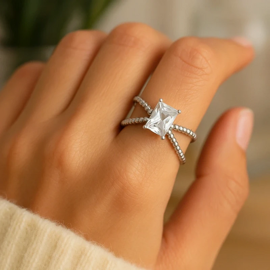 Bague de fiançailles argentée en acier inoxydable, anneau croisé serti d’un zircon rectangulaire éclatant. Élégante et intemporelle.
