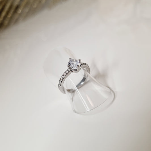 Bague en acier inoxydable couleur argent avec zircon.  L'acier chirurgical / inox / inoxydable (peut être appelé de plusieurs manières différentes) résiste à l'eau et à tout type de liquide. Vous pouvez dormir avec, vous laver/baigner avec, faire du ménage avec sans craindre que la bague ne s'abime.  Cette matière garde son éclat au fil des années et est hypoallergénique, elle convient donc pour les personnes sujettes aux allergies. 