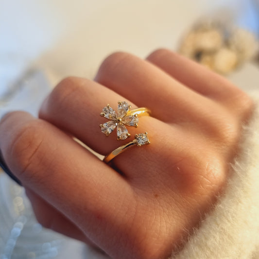  Bague ajustable en acier doré ornée d’une fleur en zircons, portée sur une main, design ouvert