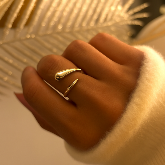Bague ouverte en acier inoxydable doré avec design en forme de gouttes minimalistes, portée sur une main