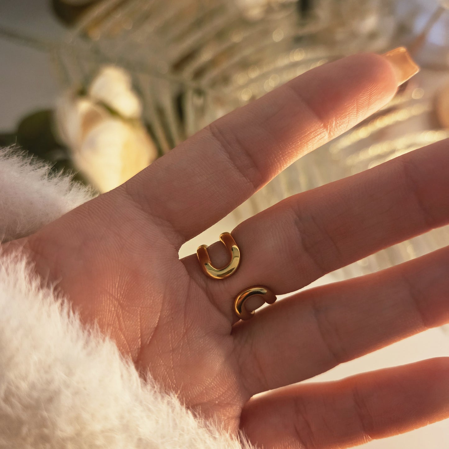 Bague initiale pavée portée sur la main, mettant en valeur la structure double anneau et la lettre centrale.