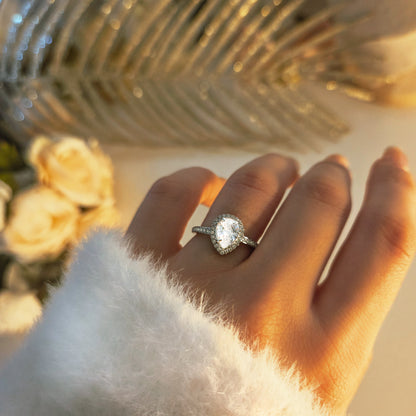 Bague élégante à pierre centrale forme poire portée à la main, bijou raffiné et lumineux