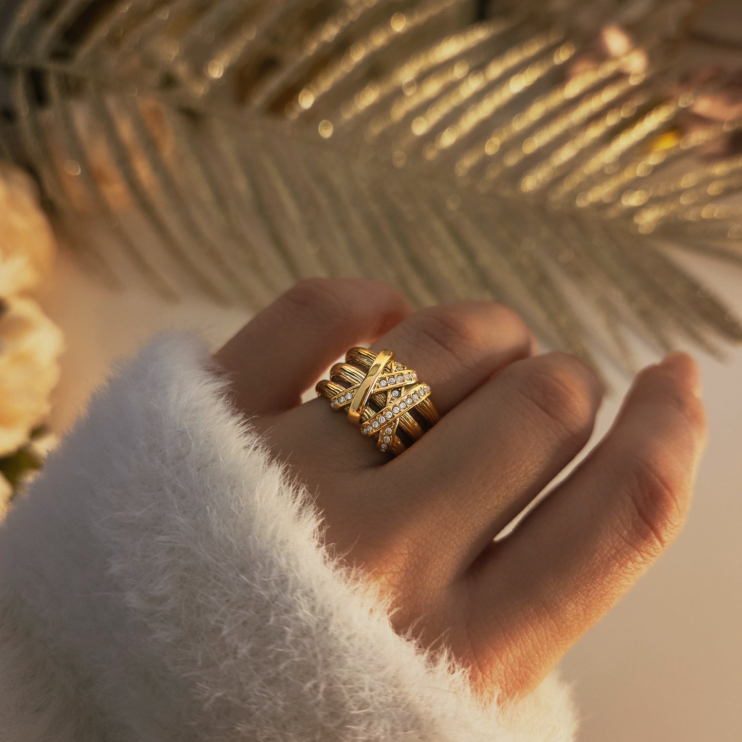 Bague femme dorée large avec design texturé et rangées de strass brillants.