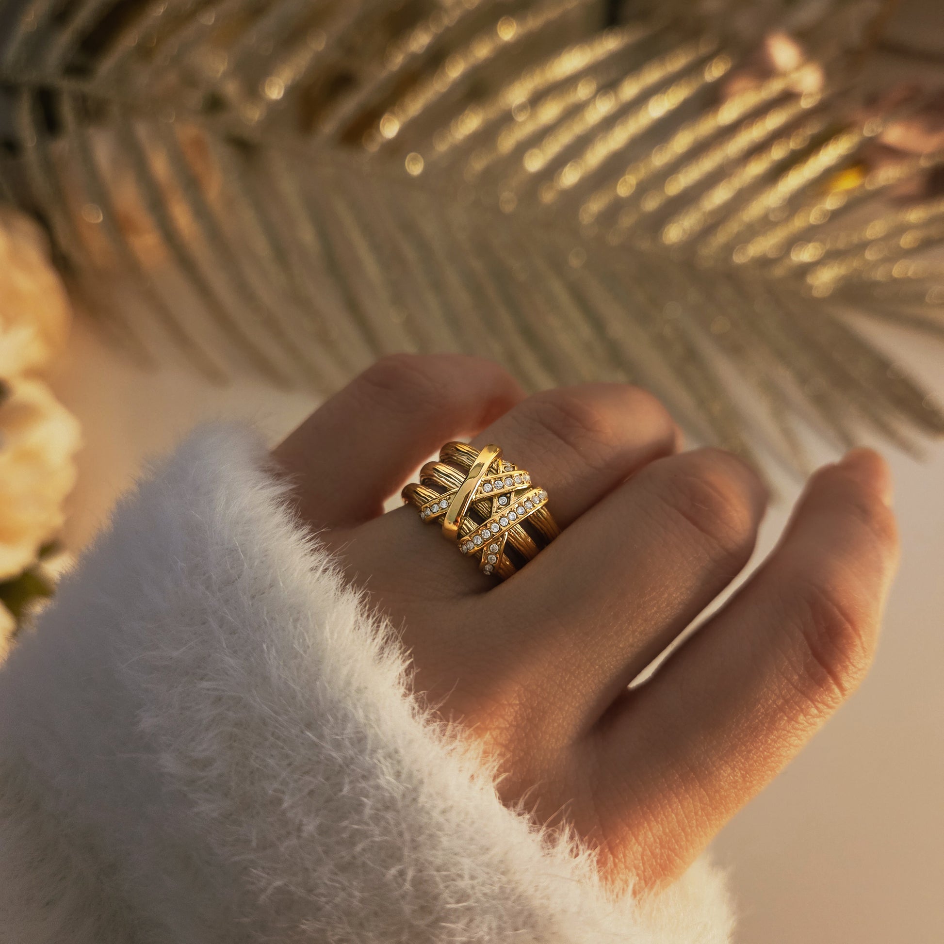 Bague femme dorée large avec design texturé et rangées de strass brillants.