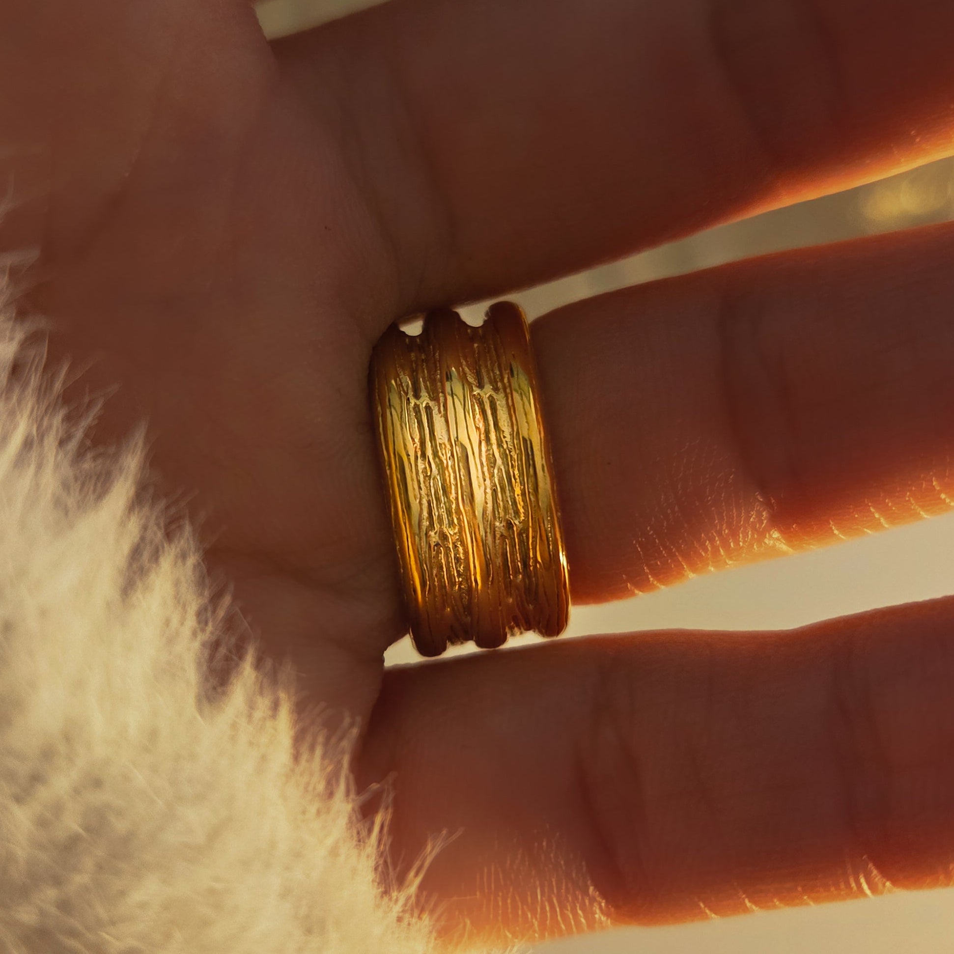 Bague femme dorée large avec design texturé et rangées de strass brillants. Vue de derrière 