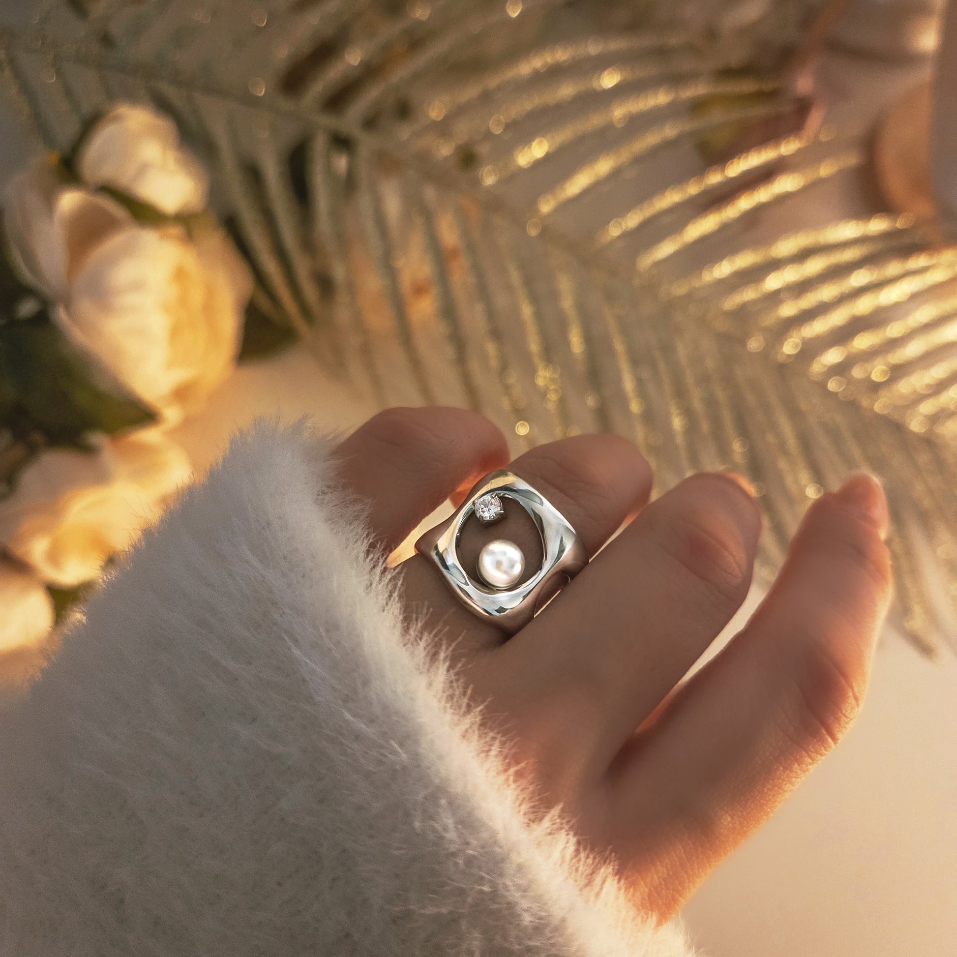 Bague large moderne avec perle centrale et détail cristal, bijou élégant porté sur la main