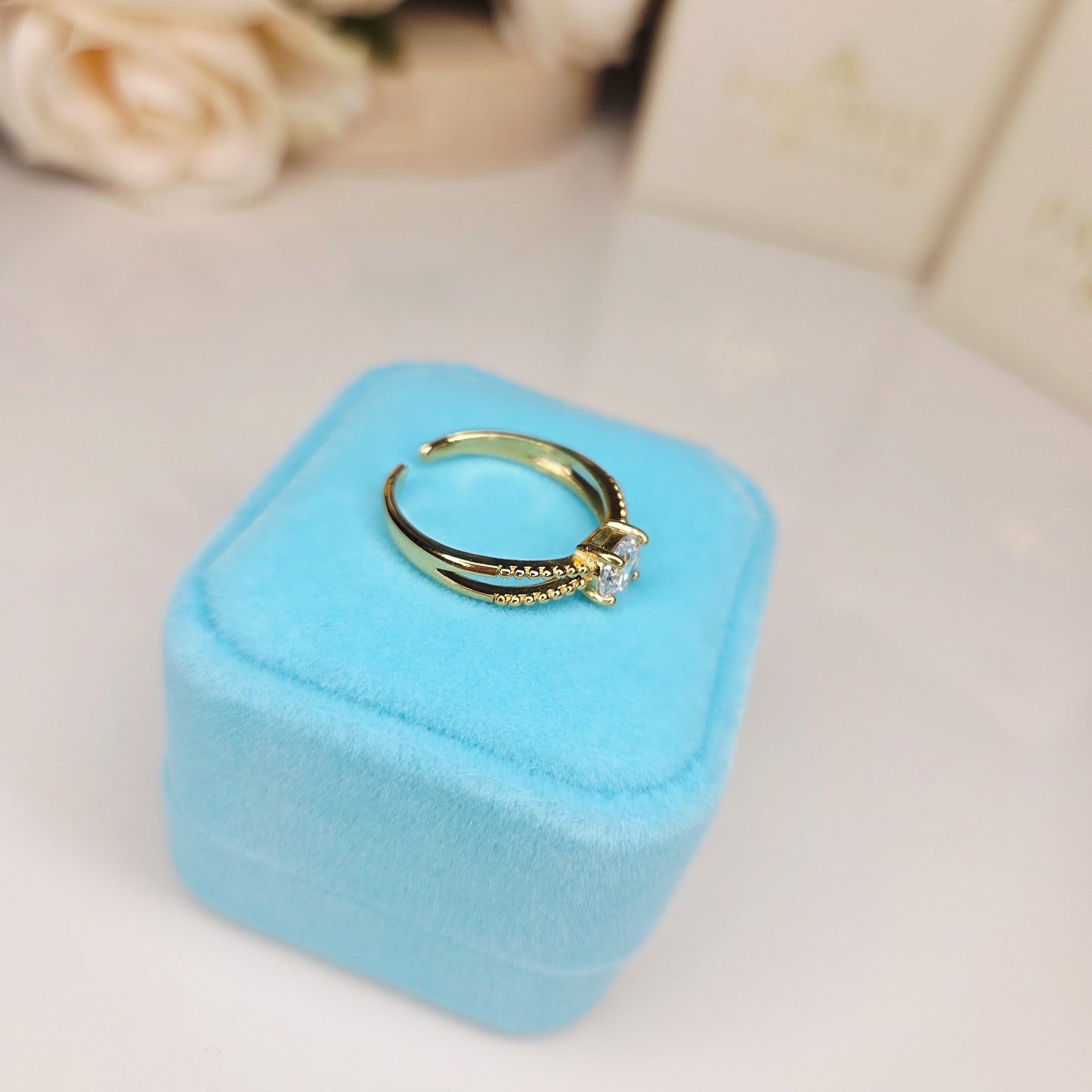 Bague solitaire sertie présentée dans un écrin, bijou élégant idéal à offrir pour une occasion spéciale vu du dessus