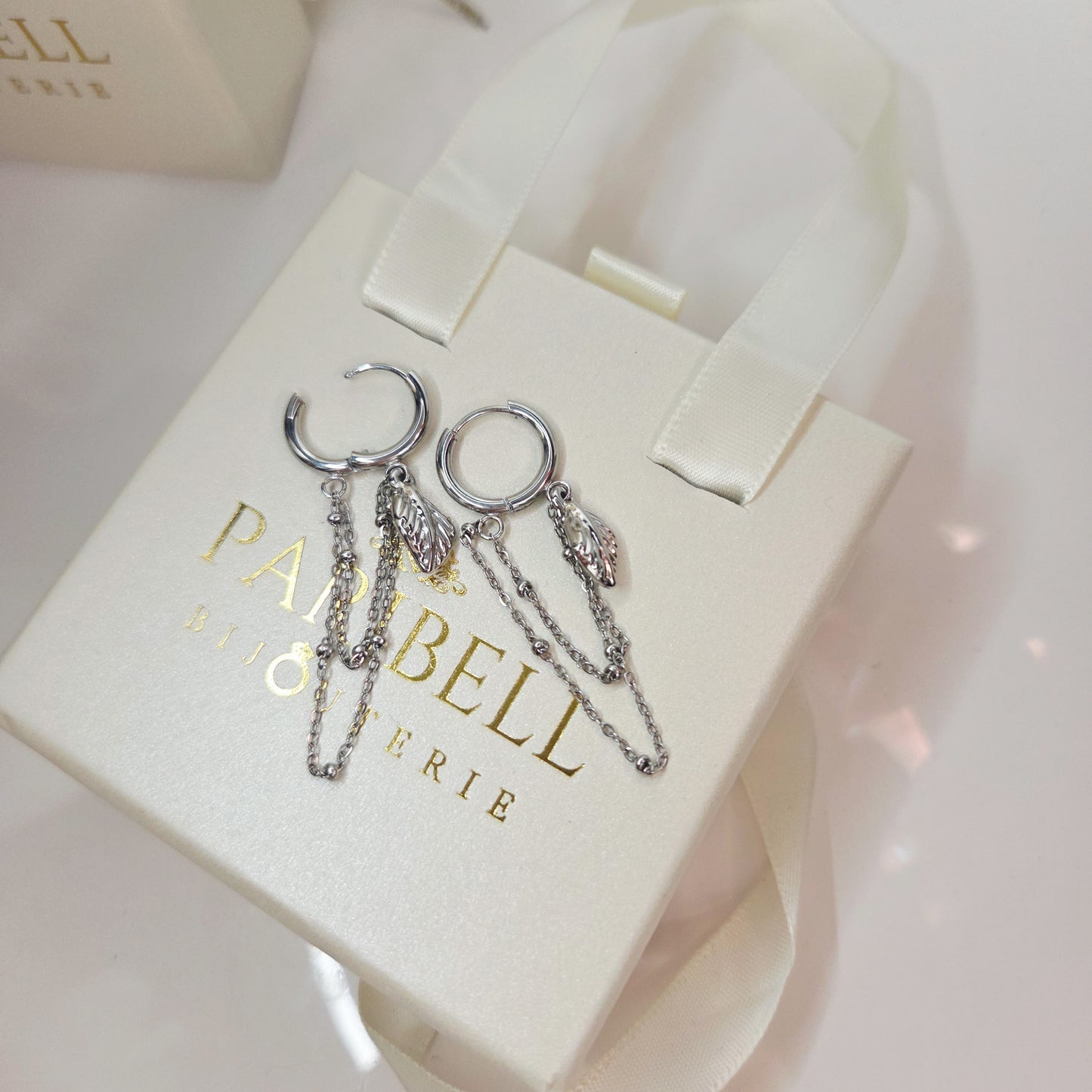 Paire de boucles d’oreilles anneaux avec chaînes fines pendantes et breloques élégantes