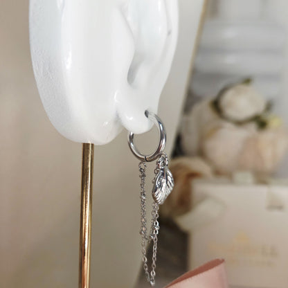 Paire de boucles d’oreilles anneaux avec chaînes pendantes et breloques. Bijou élégant et moderne, facile à porter au quotidien.