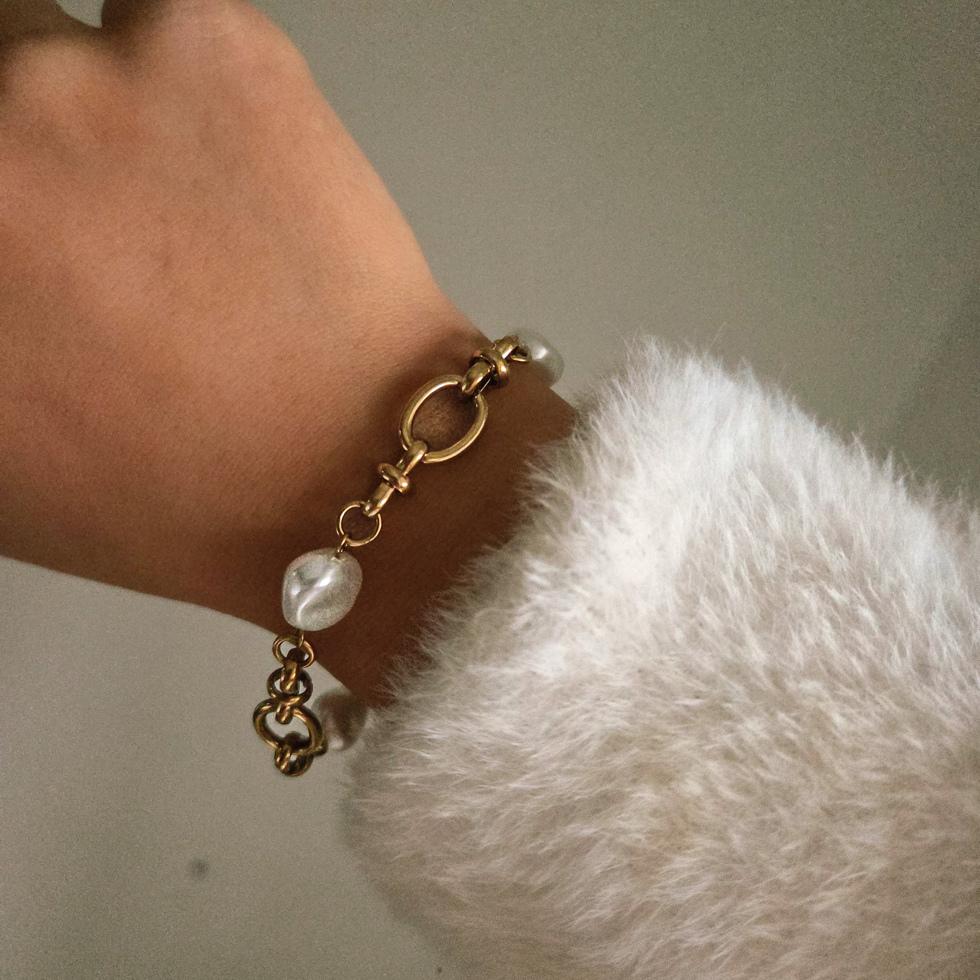 Bracelet doré avec maillons et perles porté au poignet, bijou élégant et raffiné