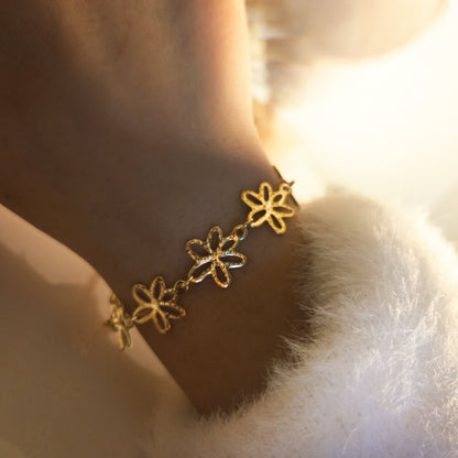 Bracelet à fleurs ajourées porté au poignet, bijou élégant et féminin au design travaillé