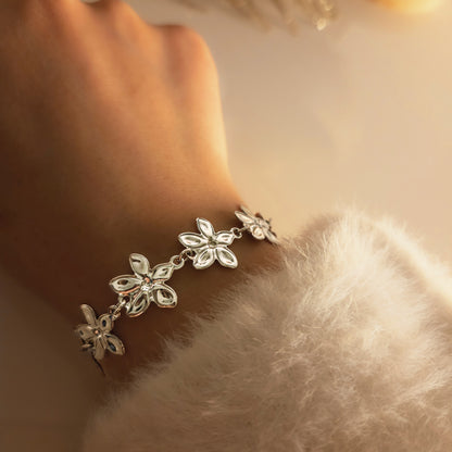 Bracelet à fleurs ajourées délicates porté au poignet, bijou féminin élégant au design raffiné