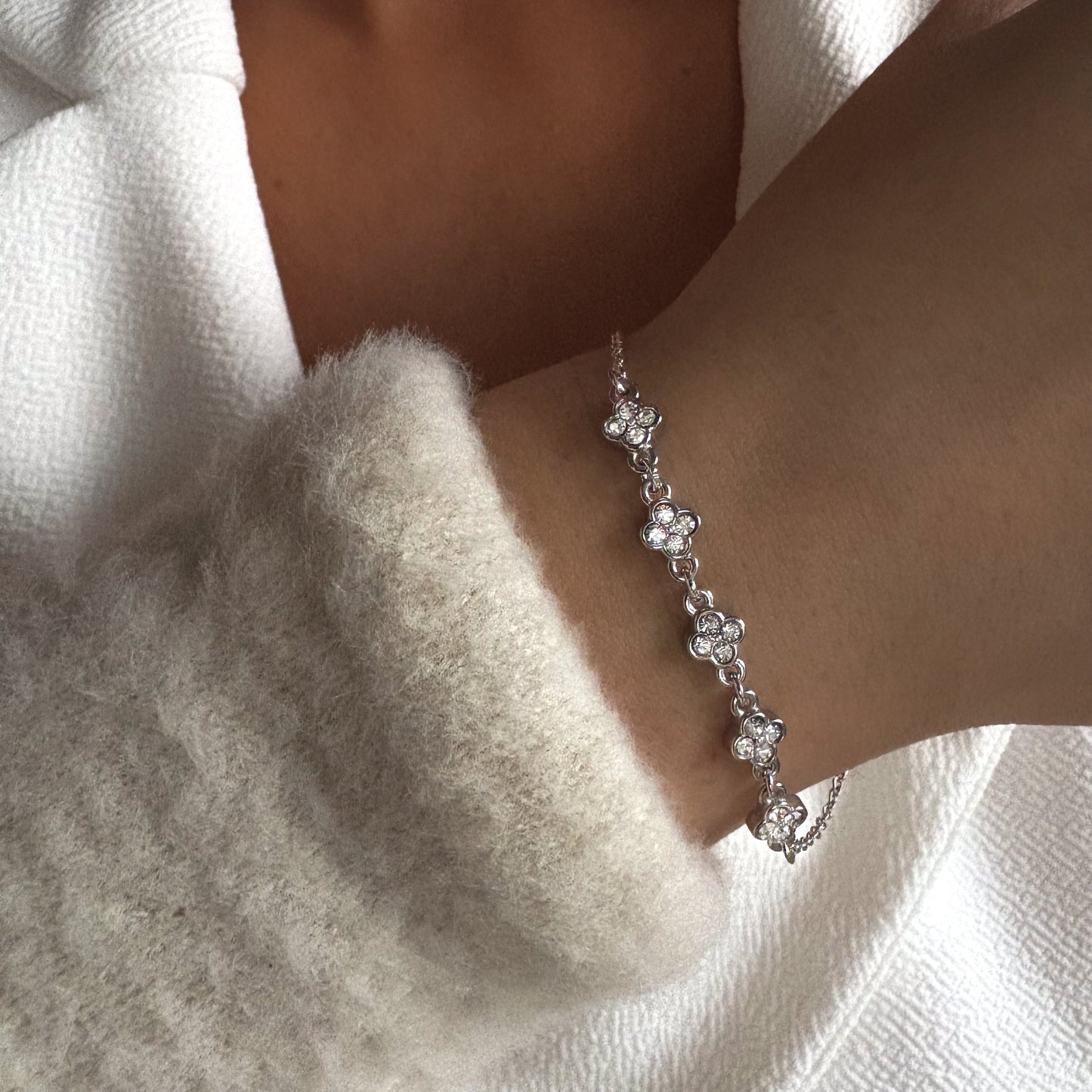 Bracelet élégant à motifs fleurs avec zircons scintillants, bijou féminin porté au poignet.