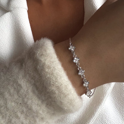 Bracelet élégant à motifs fleurs avec zircons scintillants, bijou féminin porté au poignet.