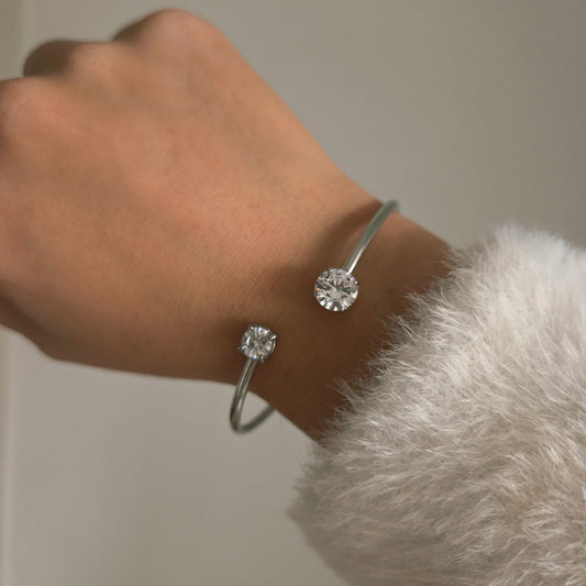 Bracelet rigide ouvert à double pierre ronde porté au poignet, bijou élégant et minimaliste