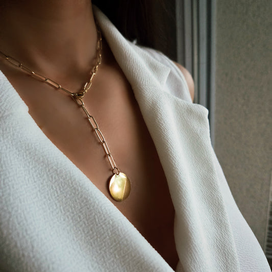 Collier à chaîne maillons avec pendentif ovale porté au cou, bijou élégant et moderne